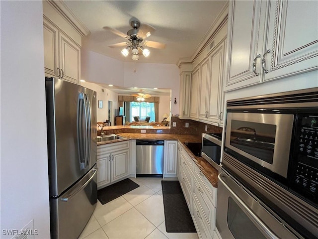 871 Tanbark Dr Unit 101, Naples, FL 34108 - kitchen featuring appliances with stainless steel finishes, ceiling fan, a sink, light tile patterned flooring, and dark countertops