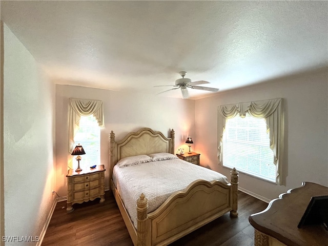 bedroom with a textured ceiling, dark wood-type flooring, and ceiling fan