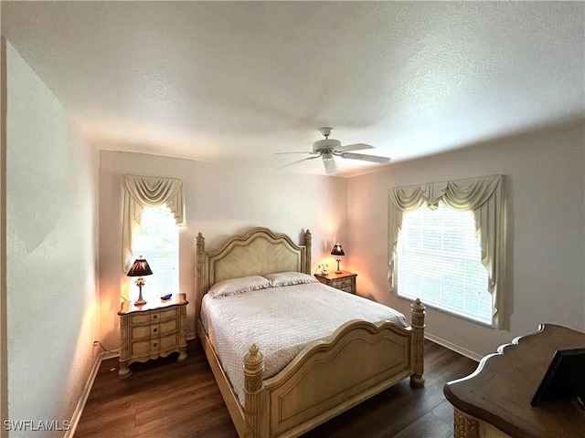 871 Tanbark Dr Unit 101, Naples, FL 34108 - bedroom with multiple windows, dark wood-type flooring, baseboards, ceiling fan, and a textured ceiling