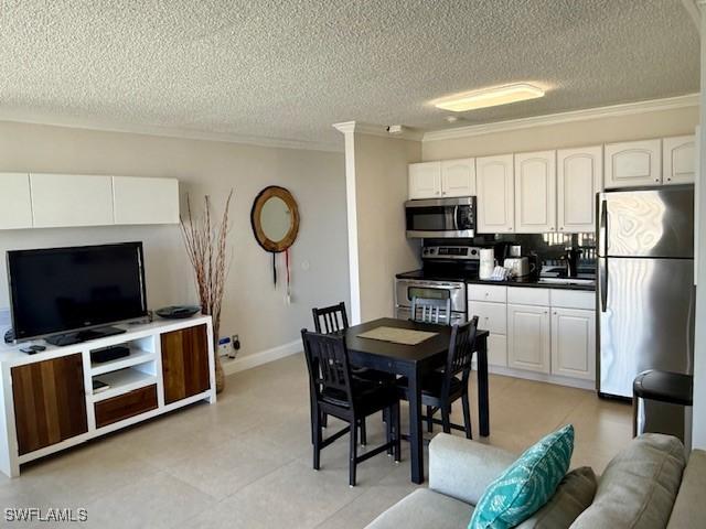 kitchen featuring white cabinetry, stainless steel appliances, and ornamental molding