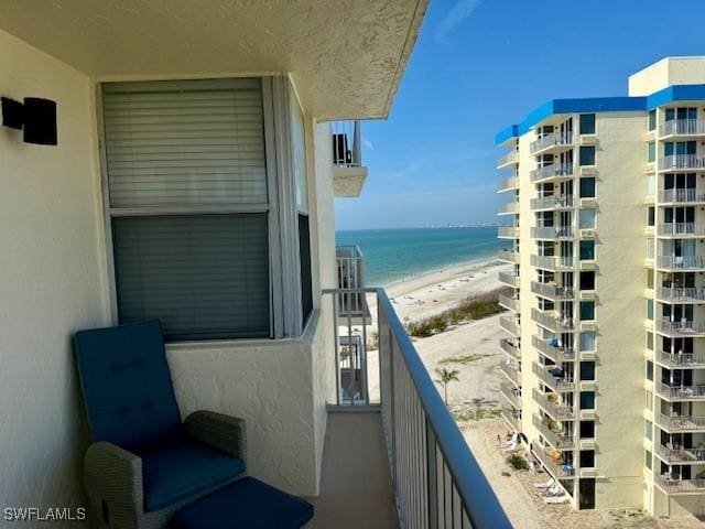 balcony featuring a beach view and a water view