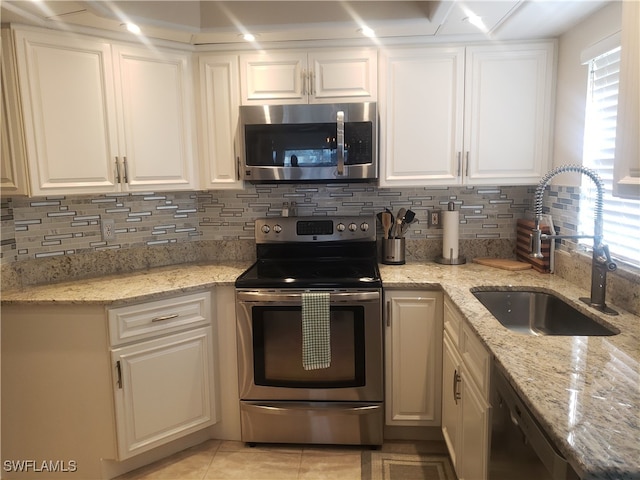 kitchen featuring white cabinetry, light stone countertops, sink, and stainless steel appliances