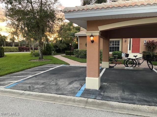 parking at dusk featuring a lawn