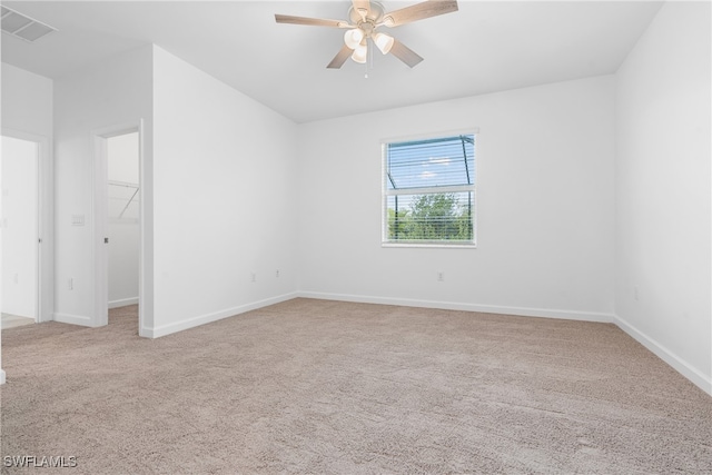 empty room featuring ceiling fan and light colored carpet