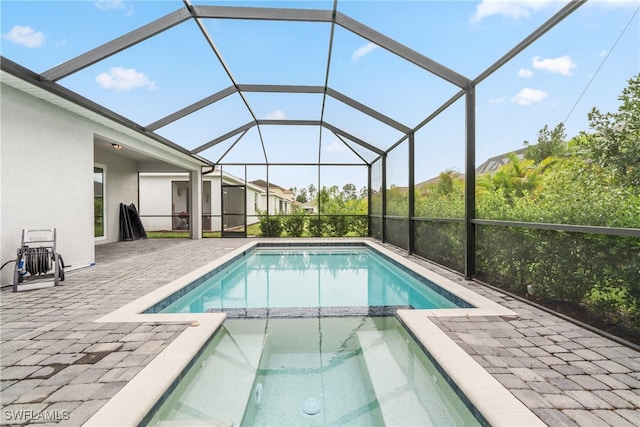 view of swimming pool featuring an in ground hot tub, glass enclosure, and a patio area