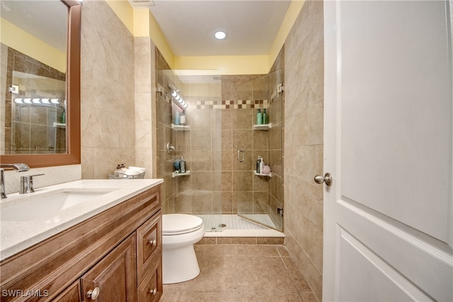 bathroom with toilet, vanity, tile patterned flooring, and a shower with shower door