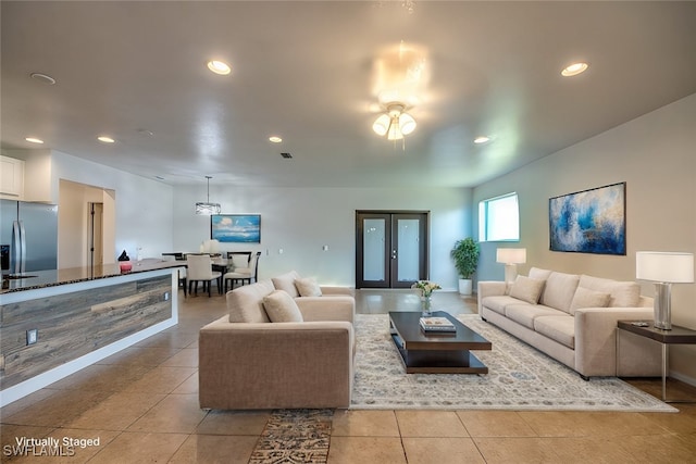 living room with french doors, light tile patterned floors, and ceiling fan