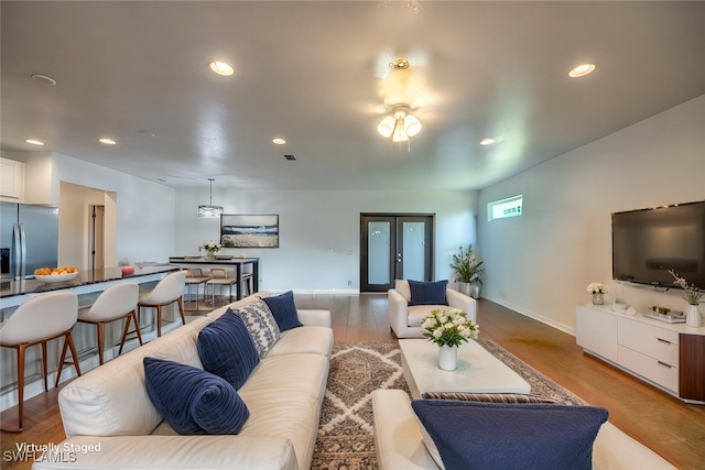 living room featuring french doors and light hardwood / wood-style flooring