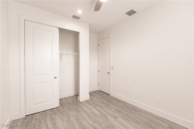 unfurnished bedroom featuring ceiling fan, a closet, and light hardwood / wood-style floors