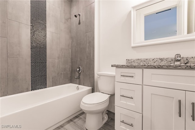 full bathroom with vanity, tiled shower / bath combo, and toilet