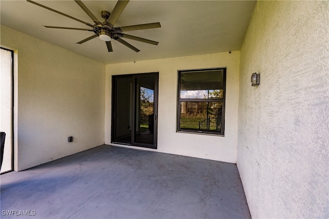 view of exterior entry featuring ceiling fan and a patio area