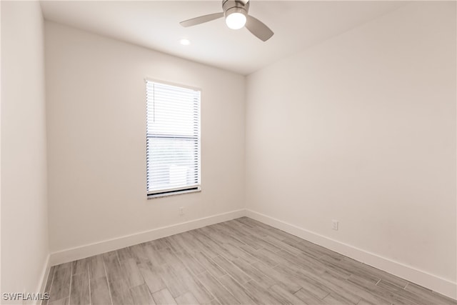 spare room with ceiling fan and light wood-type flooring