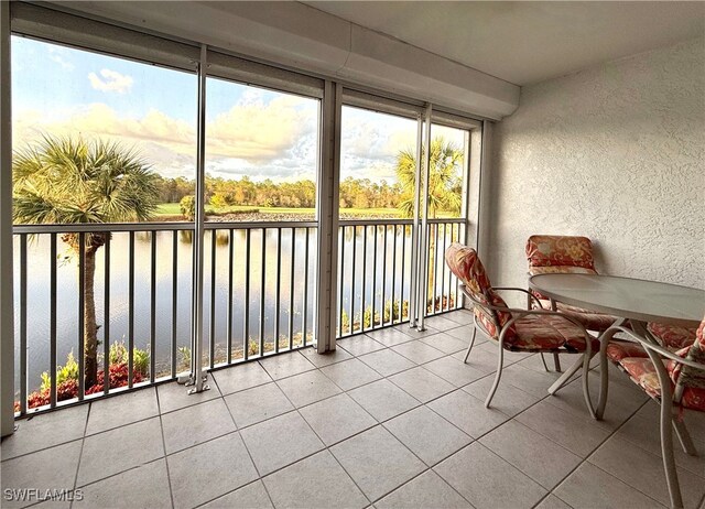 sunroom featuring a water view