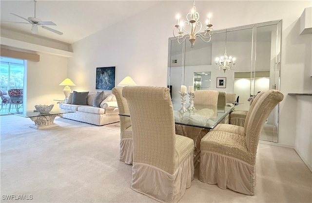 carpeted dining space with ceiling fan with notable chandelier and high vaulted ceiling