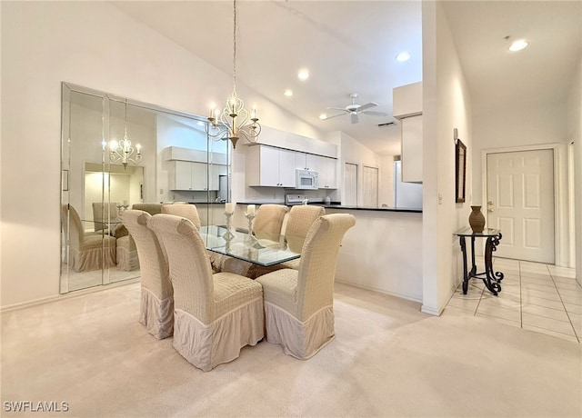 dining space featuring ceiling fan, light colored carpet, and high vaulted ceiling