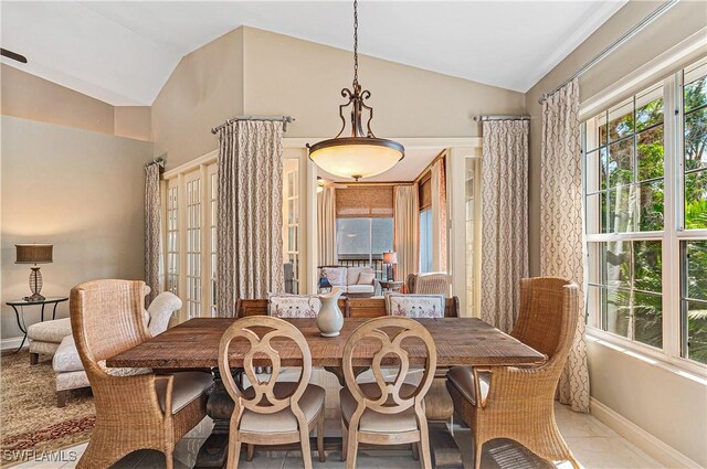 tiled dining space featuring lofted ceiling and baseboards