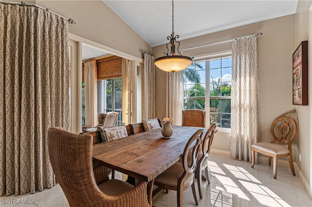 dining space featuring light tile patterned floors, plenty of natural light, baseboards, and vaulted ceiling