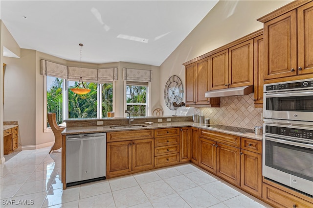 kitchen featuring stainless steel appliances, lofted ceiling, kitchen peninsula, sink, and pendant lighting