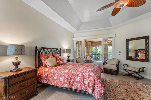 bedroom featuring access to exterior, carpet, ceiling fan, and a tray ceiling