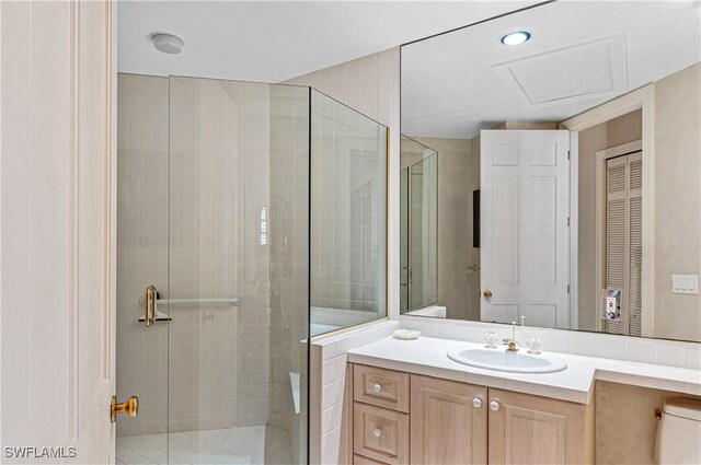 bathroom with a shower with door and vanity