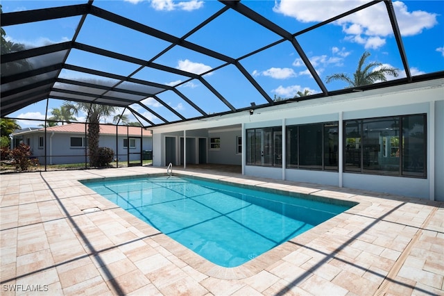 view of swimming pool featuring a patio and a lanai