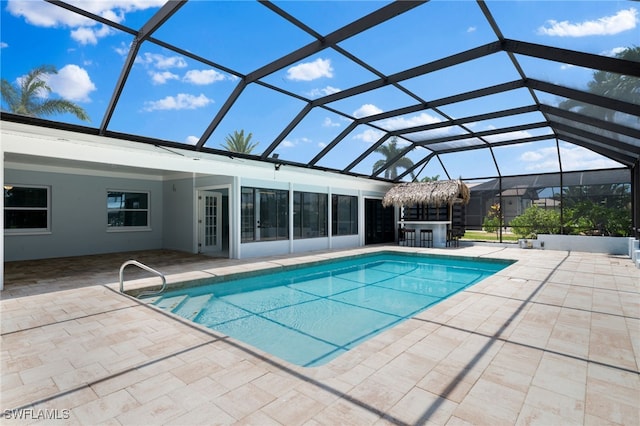 view of pool with glass enclosure and a patio