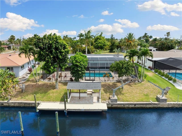 view of dock featuring a water view, glass enclosure, and a lawn