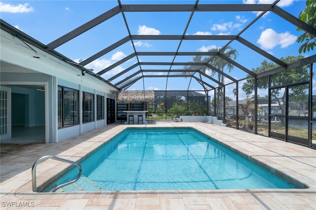 view of swimming pool with a lanai and a patio