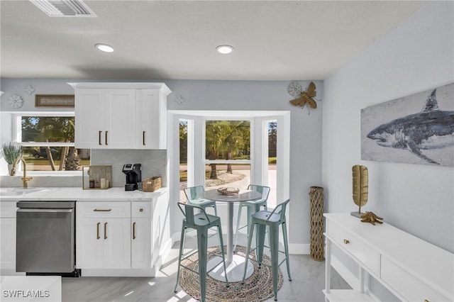 kitchen with white cabinetry, sink, tasteful backsplash, and stainless steel dishwasher