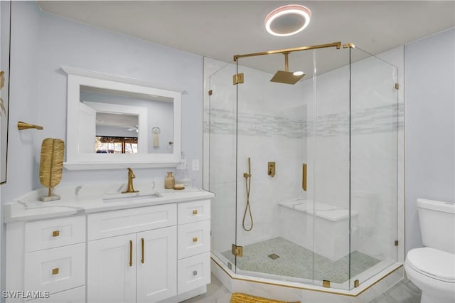 bathroom with toilet, vanity, and a shower with shower door