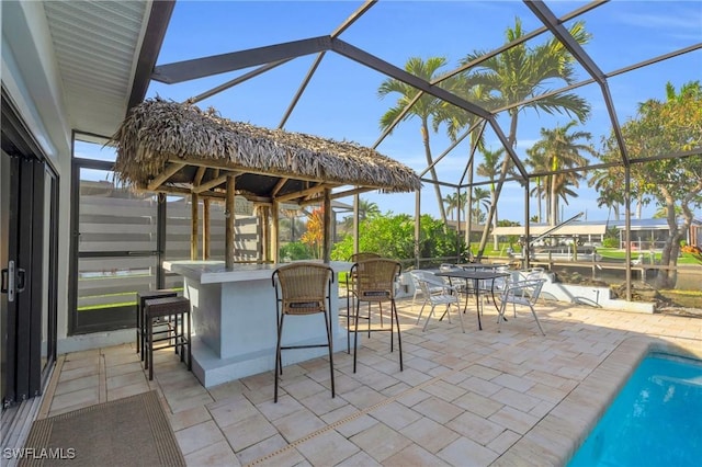 view of patio / terrace featuring glass enclosure and exterior bar