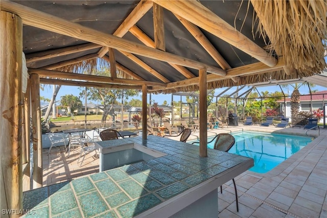 view of swimming pool featuring a patio and exterior bar