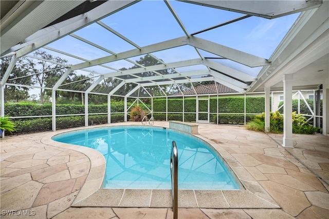 view of swimming pool featuring a patio and glass enclosure