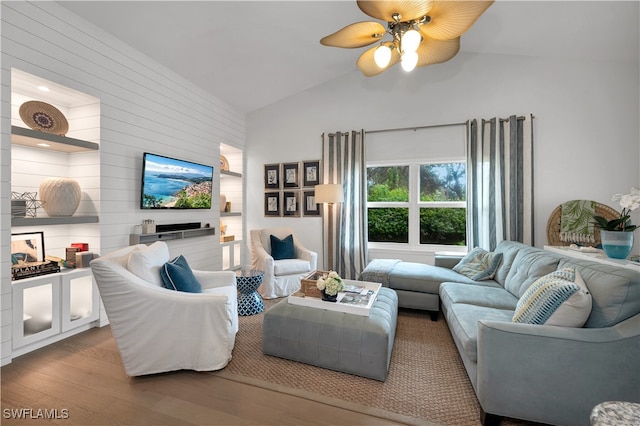 living room with hardwood / wood-style flooring, ceiling fan, and vaulted ceiling