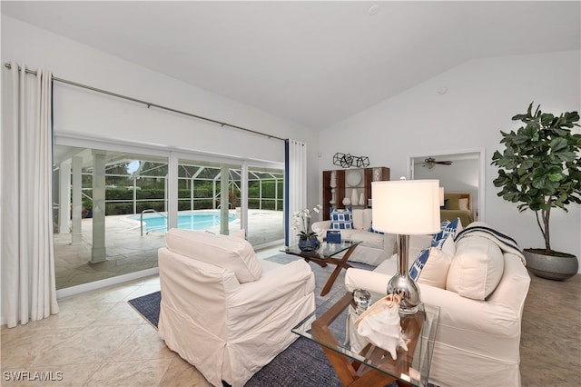 living room with ceiling fan, light tile patterned floors, and vaulted ceiling