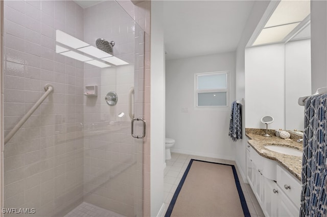 bathroom featuring walk in shower, vanity, tile patterned floors, and toilet