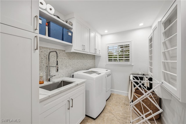 laundry area featuring cabinets, sink, washer and dryer, and light tile patterned floors