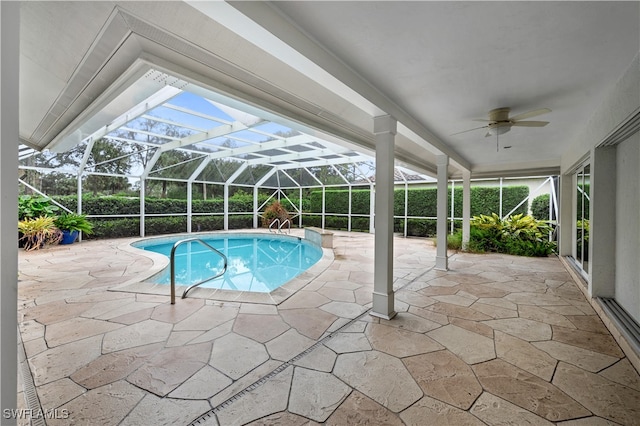 view of pool with ceiling fan, glass enclosure, and a patio area