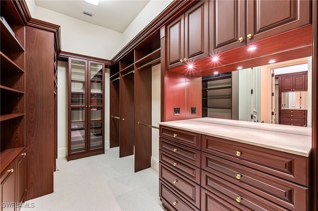 walk in closet with light carpet