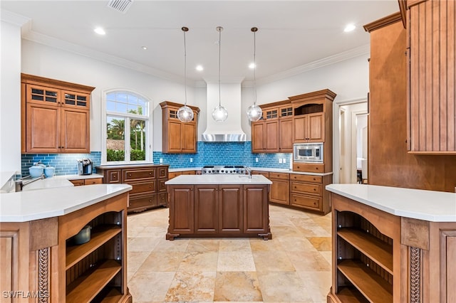 kitchen with wall chimney range hood, tasteful backsplash, decorative light fixtures, a kitchen island, and stainless steel appliances