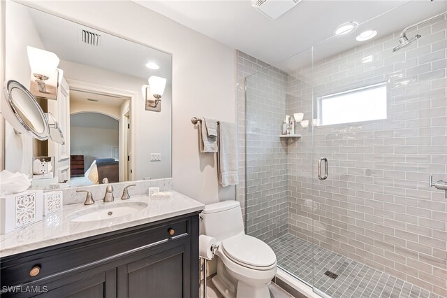 bathroom with vanity, an enclosed shower, and toilet