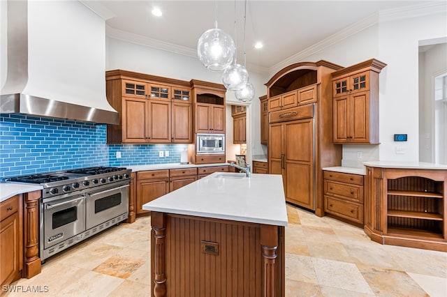 kitchen featuring wall chimney exhaust hood, stainless steel appliances, an island with sink, decorative light fixtures, and ornamental molding