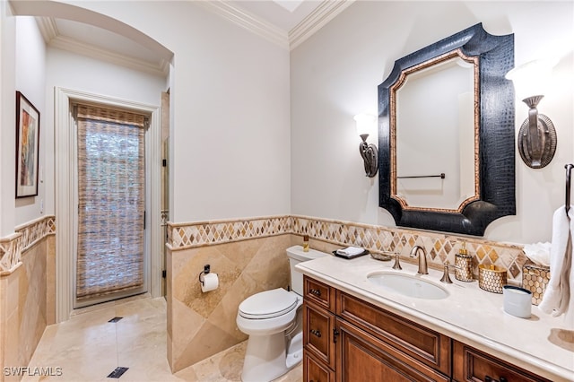 bathroom featuring vanity, toilet, tile walls, and crown molding