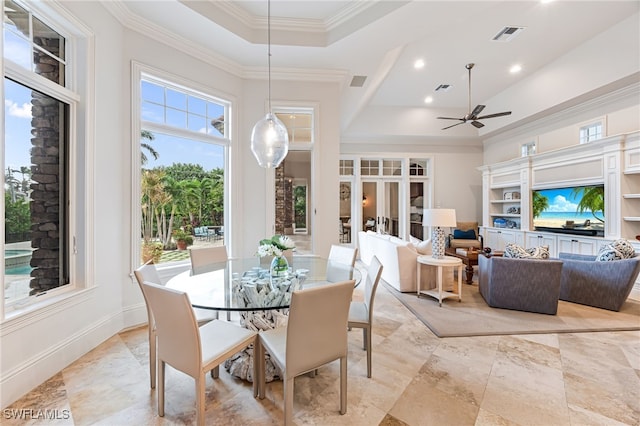 dining area with french doors, a raised ceiling, ceiling fan, and crown molding