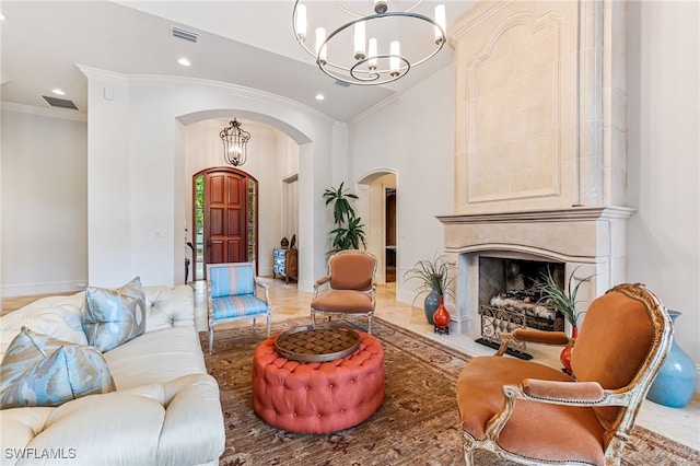 living room featuring light hardwood / wood-style floors, crown molding, a high end fireplace, and an inviting chandelier