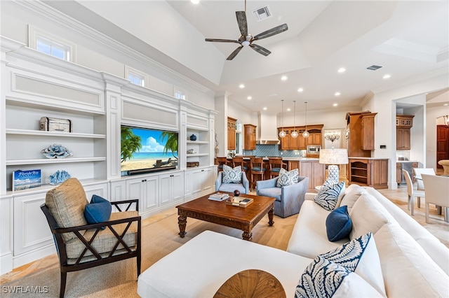 living room featuring ceiling fan, ornamental molding, and light wood-type flooring