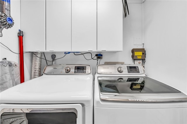 washroom featuring separate washer and dryer and cabinets