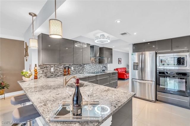 kitchen with kitchen peninsula, gray cabinetry, pendant lighting, and appliances with stainless steel finishes