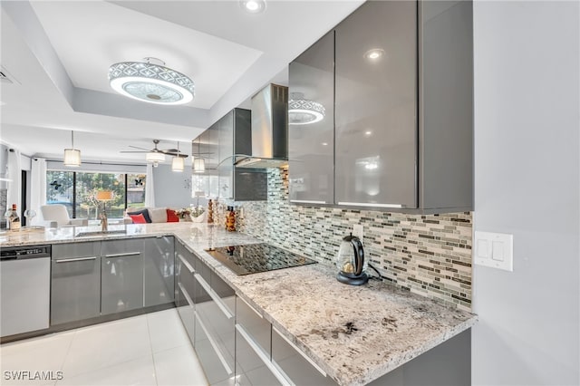 kitchen with black electric stovetop, gray cabinets, stainless steel dishwasher, kitchen peninsula, and wall chimney exhaust hood