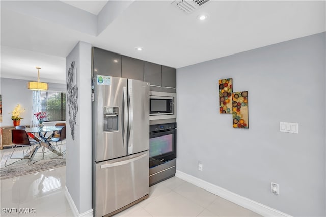 kitchen with stainless steel appliances, light tile patterned flooring, hanging light fixtures, and gray cabinetry